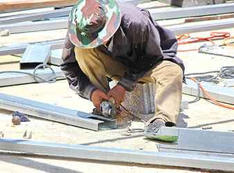 Worker Using Handheld Tool to Cut Metal worker using handheld tool to cut metal