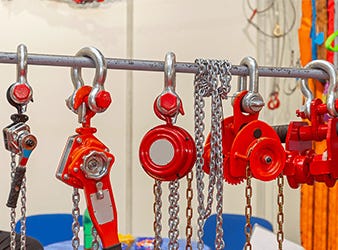 Manual and Lever Chain Hoists Hanging on Metal Bar manual and lever chain hoists hanging on metal bar