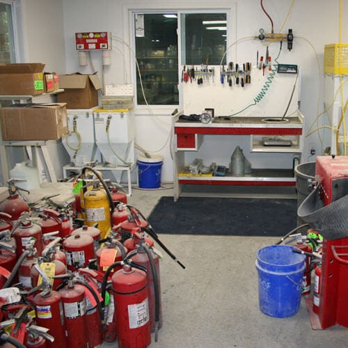Fire Extinguisher Workshop With Recharging Station and Fire Extinguishers on the Floor fire extinguisher recharging services