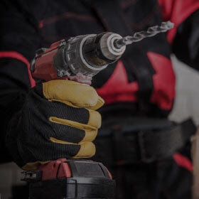 Person Gripping Power Drill That Sits on a Table person gripping power drill that sits on a table